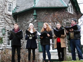 Members of the Kingston Chamber Choir sing carols outside of 14 Sydenham St. on Saturday during the Homes for the Holidays fundraising event. (Steph Crosier/The Whig-Standard)