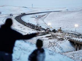 Law enforcement vehicles line a road leading to a blocked bridge next to the Oceti Sakowin camp where people have gathered to protest the Dakota Access oil pipeline in Cannon Ball, N.D., Saturday, Dec. 3, 2016. (AP Photo/David Goldman)