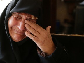 In this Sunday, Dec. 4, 2016 photo, Amina Hamawy cries after she returned to her looted home in the Hanano district of eastern Aleppo, Syria. It's a painful homecoming shared by hundreds of Syrians who are returning to areas devastated by years of war and then retaken from the city's embattled rebels in a recent government offensive. (AP Photo/Hassan Ammar)