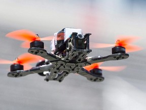 A drone hovers over the course during the Montreal drone expo, Saturday, June 25, 2016. Publicity about near-misses between drones and passenger aircraft might give terrorists ideas about how to take down a plane, a federal intelligence report warns. THE CANADIAN PRESS/Graham Hughes