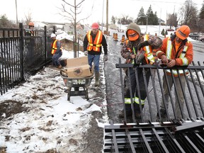 Jason Miller/The Intelligencer
Crews from Quinte Fencing install fencing along Dundas Street West. With winter weather arriving in the region construction projects are wrapping up until the spring arrives.