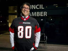 Calgary mayor Naheed Nenshi wears an obligatory smile while also wearing an Ottawa Redblacks jersey at City Hall in Calgary, Alta., on Monday, Dec. 5, 2016. He was making good on a bet with Ottawa mayor Jim Watson in the wake of the Redblacks beating the Calgary Stampeders in the Grey Cup eights days earlier. (Lyle Aspinall, Postmedia)