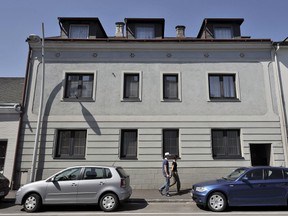 This file photo taken on May 2, 2008 shows people walking past the house where Josef Fritzl, an Austrian father who forced his daughter to bear seven of his children and held her captive for more than two decades, lived, in Amstetten, Austria. (Postmedia file photo)