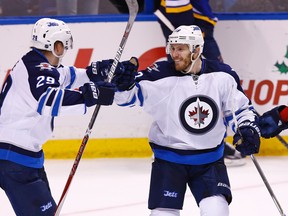 Bryan Little, right, celebrates with Patrik Laine after scoring the game-winning goal in overtime on Saturday night in St. Louis. (AP Photo/Billy Hurst)