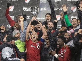 Toronto FC's Michael Bradley lifts the Eastern Conference Trophy after his team defeated the Montreal Impact during overtime MLS eastern conference playoff soccer final action in Toronto on Wednesday, November 30, 2016.THE CANADIAN PRESS/Chris Young