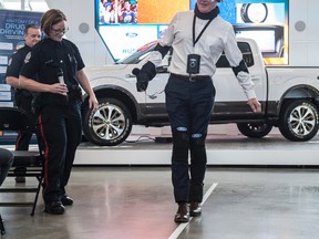 Stew MacDonald wears the Drugged Driving Suit for demonstration, which simulates the effects drugs and alcohol can have on a driver. Flashing light goggles and headphones dull the perception of a sober person and uneven ankle weights make walking even more unstable. Photo by Shaughn Butts / Postmedia