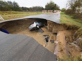 This Dec. 5, 2016, photo provided by the San Antonio Fire Department shows a sinkhole that opened up Sunday in San Antonio. Officials say Bexar County Sheriff's Deputy Dora Linda Nishihara an off-duty sheriff's deputy died and others were injured when two vehicles plunged into a water-filled sinkhole. Utility officials say the sinkhole appeared after a sewer line ruptured during heavy rain. (San Antonio Fire Department via AP)