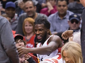 Raptors' DeMarre Carroll checks out a young lady he landed on after launching into the third row during the second half of the Toronto Raptors game against the Atlanta Hawks at the Air Canada Centre. (Stan Behal/Toronto Sun/Postmedia Network)