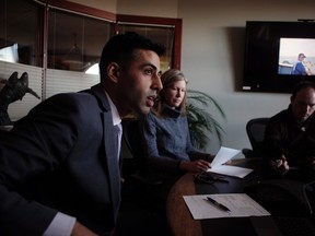 Former Canadian Navy Ordinary Seaman Nicola Peffers pictured on the television, listens in during a phone call as personal injury lawyers Natalie Foley and Rajinder Sahota with law firm Acheson Sweeney Foley Sahota, file a proposed class action lawsuit alleging sexual assault and harassment of female and LGBTQ members of the Canadian Armed Forces during a press conference in Victoria B.C., Monday, December 5, 2016. THE CANADIAN PRESS/Chad Hipolito