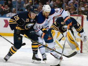 Oilers right winger Zach Kassian fights for puck possession against Sabres defenceman Jake McCabe during a trip to Buffalo last season.
(AP Photo)