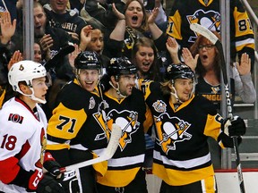 Pittsburgh Penguins' Justin Schultz (4) celebrates his goal with teammates Evgeni Malkin (71), and Carl Hagelin (62) in the second period of an NHL hockey game against the Ottawa Senators in Pittsburgh, Monday, Dec. 5, 2016. (AP Photo/Gene J. Puskar)