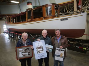 Friends of the Phoebe volunteers Paul Jeffrey, from left, and Henk Wevers are seen with Henry Copestake of the St. Lawrence II tall ship in front of the Phoebe in its new home in the sail-measuring room at Portsmouth Olympic Harbour. The Friends of the Phoebe and the St. Lawrence II will be hosting an event on Thursday from 3 to 5 p.m. to welcome the vessel to its new indoor home. (Ian MacAlpine/The Whig-Standard)