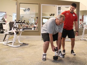 John Paton works with his personal trainer, Jeremy Cocchetto, at GoodLife Fitness in Woodstock on Tuesday, Dec. 6, 2016. Paton started working out to aid his recovery after a serious motor vehicle collision. He's now a finalist in GoodLife Fitness' Transformation Challenge. (MEGAN STACEY/Sentinel-Review)