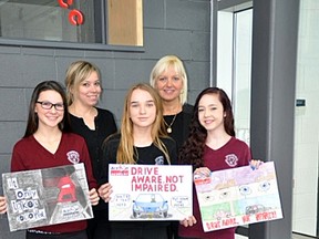 Riley Banks, Alyssa MacDonald and Violet Landrie with their posters and their at teacher, Christina Thompson, and Principal Patty Mardero. Three St. Charles College students were presented with first-, second- and third-place awards in an Action Sudbury poster contest to bring awareness to driving impaired.  The students will soon see their posters on the back of city buses. Photo supplied