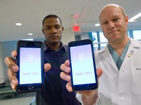 App developer Francis Yanga, left, and surgeon Brian Rotenberg, right, show off a smartphone app, PageMe, at St. Joseph?s Health Care Tuesday. The app is more secure than texting, but easier than paging for consultations about confidential patient information. (CRAIG GLOVER, The London Free Press)