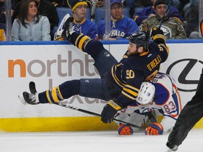 Oilers defenceman Matt Benning collides with Sabres forward Ryan O'Reilly during the first period of Tuesday's game in Buffalo, N.Y. (AP Photo)