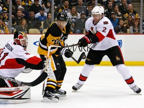 Senators’ Dion Phaneuf tries to bat a rebound away from Penguins’ Patric Hornqvist in front of Craig Anderson on Monday night. (AP)