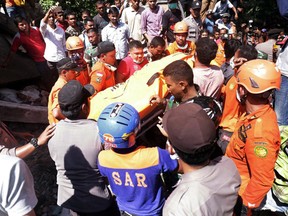 Rescuers carry a body bag containing the body of a victim recovered from under the rubble of a building that collapsed after an earthquake in Pidie Jaya, Aceh province, Indonesia, Wednesday, Dec. 7, 2016. A strong undersea earthquake rocked Indonesia's Aceh province early on Wednesday, killing a number of people and causing dozens of buildings to collapse. (AP Photo/Heri Juanda)