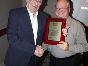 Jim Kenny, left, accepts the Lumber and Building Materials Association of Ontario's 2016 Industry Achievement Award at a celebration Nov. 10 in Orangeville. Kenny has spent 30 years with the professional organization as a member, board appointee and staffer.