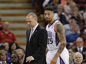 Sacramento Kings forward Royce White walks past Kings head coach Michael Malone to enter his first NBA basketball game in the closing moments of the Kings 99-79 loss to the San Antonio Spurs in Sacramento, Calif., White was drafted by the Houston Rockets with the No. 16 pick in the 2012 draft but spent his rookie season in a dispute with the team over how to treat his anxiety disorder which includes a fear of flying. (AP file photo)
