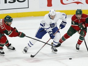 Toronto Maple Leafs' Zach Hyman controls the puck through the defense of Minnesota Wild's Jason Pominville, left, and Jared Spurgeon, right, in the first period of an NHL hockey game Thursday, Oct. 20, 2016, in St. Paul, Minn. (AP Photo/Stacy Bengs)