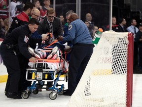 Vancouver Canucks defenceman Philip Larsen is carried onto a stretcher after a hit by New Jersey Devils left wing Taylor Hall during the second period on Dec. 6. (AP photo)