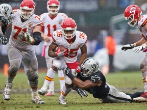 Kansas City Chiefs running back Spencer Ware is tackled by a Raiders defender earlier this year. (GETTY IMAGES)
