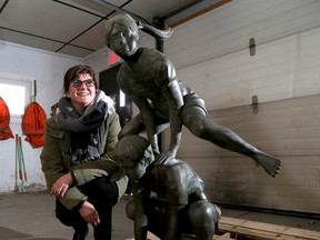 Maura Doyle of Hospice Kingston with the returned statue featuring leapfrogging children which is now stored at a City of Kingston storage facility. (Ian MacAlpine/The Whig-Standard)