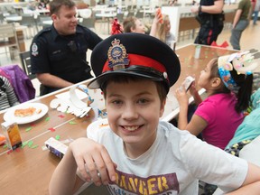 Austin Dampier borrowed the hat from Const. Liam Watson. Londonderry Mall hosted 10 EPS members  and 20 students from four different north east  schools to participate in the first ever CopShop. This event unites Edmonton’s youth and police officers for an afternoon of Christmas shopping  and to meet and enjoy  time spent with local police officers on December 7,  2016.  Photo by Shaughn Butts / Postmedia