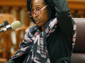 Former Greenville, Miss., teacher Linda Winters-Johnson demonstrates how she believes she grazed a student's head with a reinforced cup of ice, Wednesday, Dec. 7, 2016, during a teacher licensure commission hearing in Jackson, Miss. Winters-Johnson actions which were video recorded, allegedly show her dragging a special education student by the hair across the floor of the Greenville High School gym Sept. 21. The commission voted to suspend Winters-Johnson's teaching license for 12 years. (AP Photo/Rogelio V. Solis)