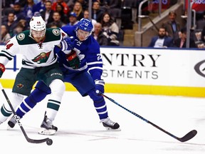 Toronto Maple Leafs' Nikita Zaitsev gets tangled up with Minnesota Wild's Tyler Graovac during an NHL game in Toronto on Dec. 7, 2016. (Michael Peake/Toronto Sun/Postmedia)