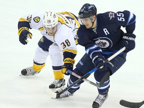 Nashville Predators left winger Viktor Arvidsson and Winnipeg Jets centre Mark Scheifele (right) chase down a loose puck during a game last month. Scheifele returns to the Jets' lineup on Thursday night. (Brian Donogh/Winnipeg Sun file photo)