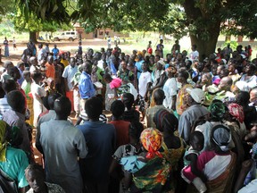 In this photo taken Tuesday, Nov. 15, 2016, a UN Refugee Agency (UNHCR) official speaks to a group of civilians during a distribution of food items in Yei, in southern South Sudan. The formerly peaceful town of Yei, surrounded by farms in southern South Sudan was once a beacon of coexistence, but Yei is now a centre of the country's renewed civil war and it gripped by a wave of killings among the dozens of ethnic groups. (AP Photo/Justin Lynch)