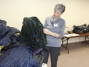 Anne Rutherford, a member of the Hotel Dieu Hospital/St. Mary’s Cathedral coat drive committee, looks over items donated. The drive is running short of large and extra large men’s coats this year. (Michael Lea/The Whig-Standard)