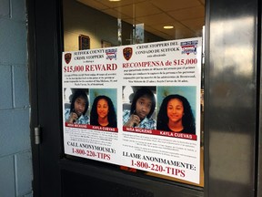 In this Oct. 24, 2016 file photo, a poster displayed at a Suffolk County police precinct in Bay Shore, N.Y., offers a $15,000 reward for information leading to the arrest of the person(s) responsible for the slayings of 15-year-old Nisa Mickens and her lifelong friend 16-year-old Kayla Cuevas. (AP Photo/Michael Balsamo, File)
