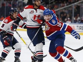 Davis Koch battles a pair of Hurricanes during Monday's game at Rogers Place. (Ian Kucerak)