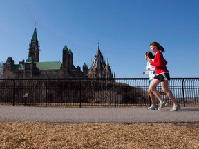 Joggers make their way through Majors Hill Park in downtown Ottawa in view of Parliament Hill on Wednesday, March 17, 2010. (THE CANADIAN PRESS/Sean Kilpatrick)