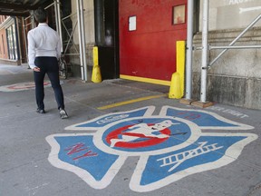 In this July 12, 2016, file photo, a man walks past the firehouse that was featured in the 1984 movie "Ghostbusters," in New York. The New York Daily News reports a Ghostbusters fan from Britain flew with his girlfriend to New York on Monday, Dec. 5, 2016, to propose at the firehouse. (AP Photo/Seth Wenig, File)