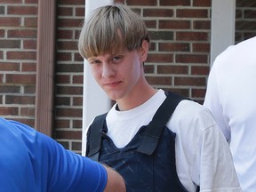 In this June 18, 2016 file photo, Dylann Roof is escorted from the Sheby Police Department in Shelby, N.C. The trial for Roof, a white man accused of killing nine black people at the church, started Wednesday, Dec. 7, 2016, at the federal courthouse in Charleston, S.C. (AP Photo/Chuck Burton, File)