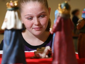 Tim Miller/The Intelligencer
Student Sinead Summers takes a closer look at a nativity scene from China at the annual Nativity Project at Queen of the Most Holy Rosary Catholic Church on Friday.