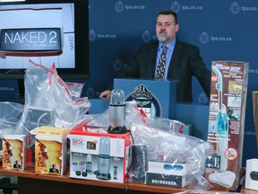 Det. Rob Whalen with seized counterfeit merchandise on Dec. 9, 2016 at police headquarter. (Veronica Henri/Toronto Sun)