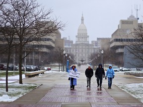 Michigan residents walk towards the Michigan State Supreme Court for a rally to speak out against the courts decision to shut down Michigan's recount on Thursday, Dec. 8, 2016 in Lansing. Michigan's recount of presidential votes is over after a judge lifted an order that forced a statewide review of millions of ballots. The recount lasted three days in more than 20 of the state's 83 counties. (Samantha Madar /Jackson Citizen Patriot via AP)