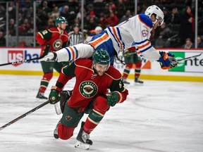 Edmonton Oilers forward Benoit Pouliot flies over Minnesota Wild's defenceman Marco Scandella on Friday, Dec. 9, 2016, in St. Paul, Minn.