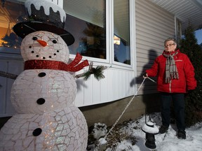 Marion Broverman shows the chain that now secures a snowman decoration, a replacement for a larger snowman, stolen on Dec. 8, that was the centrepiece to her Christmas lights in Edmonton, Alberta on Friday, December 9, 2016. Ian Kucerak / Postmedia
