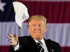 U.S. President-elect Donald Trump tosses a "Make America Great Again" hat into the crowd while speaking at the Dow Chemical Hangar, Dec. 9, 2016 in Baton Rouge, La.  (Drew Angerer/Getty Images)