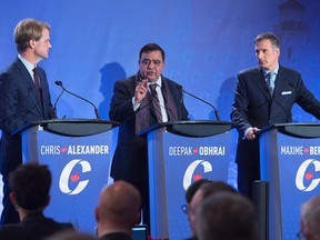 Deepak Obhrai is flanked by Chris Alexander, left, and Maxime Bernier at the Conservative leadership candidates' bilingual debate in Moncton, N.B. on Tuesday, Dec. 6, 2016. Conservatives vote for a new party leader on May 27, 2017.