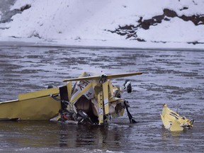 A Grumman American AA-1 aircraft lies in the middle of the Etchemins River Saturday, December 10, 2016 in Levis Que. The plane crashed after it hit power lines. Two people were on board and were evacuated by ambulance. THE CANADIAN PRESS/Jacques Boissinot