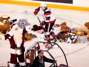David Pearce of the 67’s helps clear the ice while Santa Claus urges on the crowd after Ottawa’s first goal against the Oshawa Generals resulted in the annual Teddy Bear Toss on Dec. 10 at TD Place. (Patrick Doyle, Postmedia Network)
