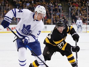 Auston Matthews of the Toronto Maple Leafs battles with Austin Czarnik of the Boston Bruins for the puck during the first period in Boston on Dec. 10, 2016. (MICHAEL DWYER/AP)