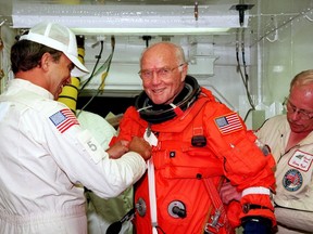 This file photo taken on October 9, 1998 shows US astronaut and Senator John Glenn getting a hand from white room technicians moments before boarding the US space shuttle Discovery. Glenn, who made history twice as the first American to orbit the Earth and the first senior citizen to venture into space, has died at the age of 95, the Ohio State University's John Glenn College of Public Affairs said on December 8, 2016. (AFP PHOTO / NASA / HOHO/AFP/Getty Images)